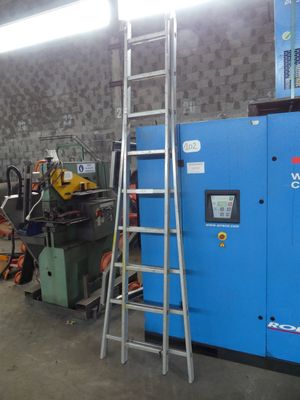 a ladder leaning against a wall next to a blue machine