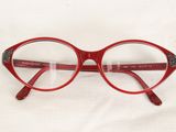 a pair of red glasses on a white surface