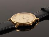 an image of a close up of a wrist watch on a black surface