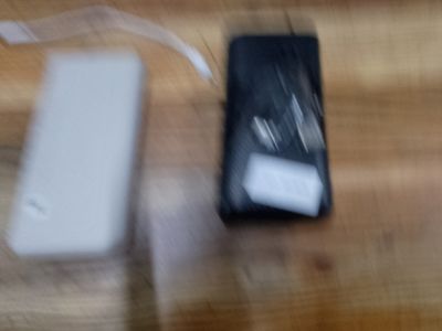 une photo floue montrant un téléphone portable et un chargeur posés sur une table