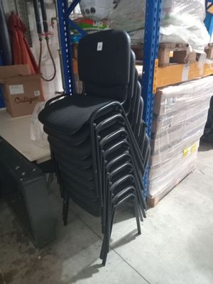 a lot of chairs that are stacked up in a warehouse