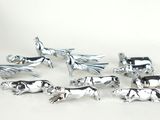 un ensemble de figurines d'animaux en argent posées sur un fond blanc