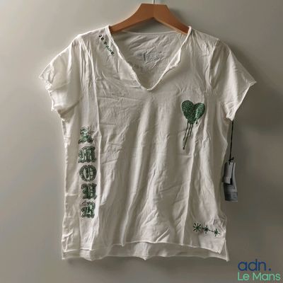 T-shirt blanc à col en V avec des feuilles vertes sur la poitrine