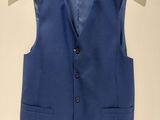 a blue vest hanging on a hanger on a wall