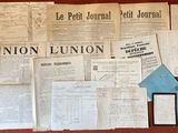 plusieurs journaux et documents posés sur une table sur laquelle se trouve un téléphone portable