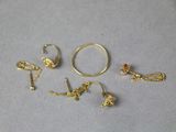 three pairs of gold rings and a pair of earrings on a table