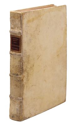 an old book sitting on top of a white table next to a white wall