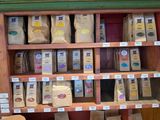 many bags of coffee sitting on a shelf in a store