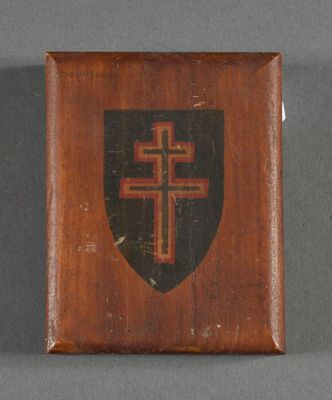 an old wooden plaque with a cross and shield on it