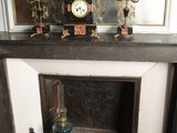 a mantle with a clock on top of it in a room