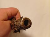 a hand that is holding a small pipe in it ' s left hand