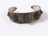 a close up of a silver bracelet on a white surface