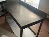 une table dans la cuisine, avec une feuille de papier posée à côté
