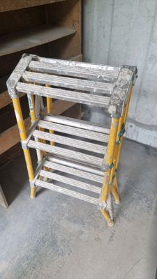 a stack of ladders sitting on the floor in a room