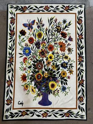 une photo d'un patchwork sur lequel figure un vase de fleurs