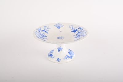 small blue and white footed bowl on a white background