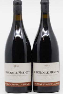 deux bouteilles de vin rouge posées l'une à côté de l'autre sur une surface blanche