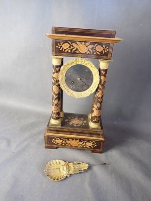une horloge posée sur une table à côté d'un ventilateur