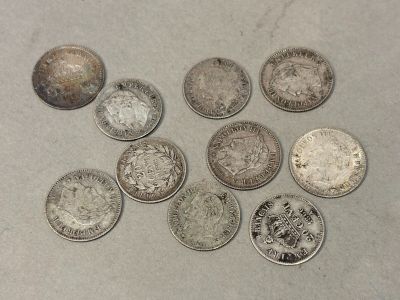 Six types différents de pièces d'argent sont disposés sur une table.