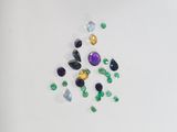 several different colored gems are scattered on a white surface