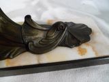 une statue représentant un oiseau posée sur un socle en marbre