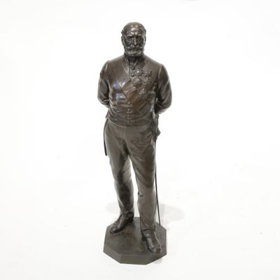 statue d'un homme muni d'une canne, debout sur une surface blanche