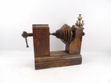 une machine à l'ancienne, avec un socle en bois posé sur une surface blanche