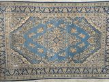 un tapis bleu et beige orné d'un motif en médaillon