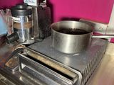a pot of coffee on a stove with a toaster on it
