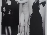 black and white photograph of two women standing in front of a statue