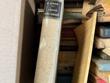 a cardboard box filled with books and a roll of paper