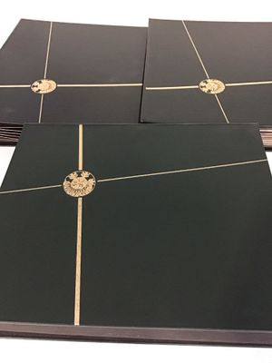 quatre classeurs noirs avec des bordures dorées et une couronne sur la couverture