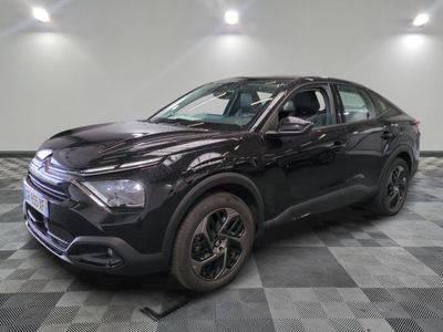 Un SUV noir est garé dans une grande pièce au sol carrelé.