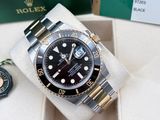 a rolex watch in a box with a keychain next to it