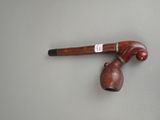 a pipe with a wooden handle and a bell attached to it