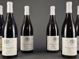 six bouteilles de vin sont alignées sur une table