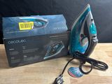 an electric iron sitting on top of a wooden table next to a box