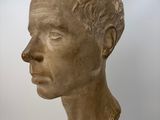 marble bust of a man in profile on a wooden base