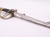 an old sword with a metal handle on a white surface