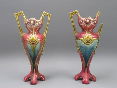 une paire de vases colorés posés l'un sur l'autre sur une surface grise