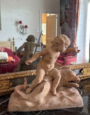 Sujet en terre cuite représentant un putto assis sur un daup…