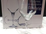 un verre à vin posé devant une boîte sur une table