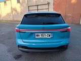 the rear end of a blue car parked in a parking lot