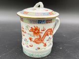 une image représentant une tasse ornée d'un dragon, posée sur une table