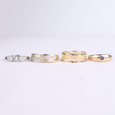 three gold and silver rings with blue sapphire stones