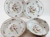 three plates with birds and flowers on them sitting on a table