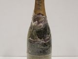 an old bottle of champagne sitting on top of a white table