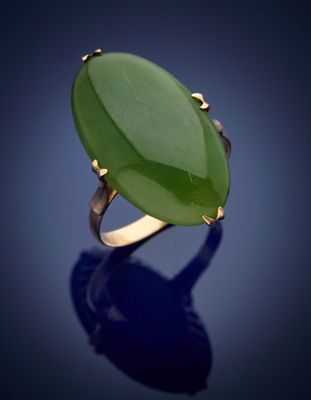 une bague ovale en jade vert sur fond bleu