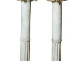 pair of white marble pedestals with columns on top of them