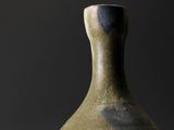 a vase that is sitting on a table with a black background